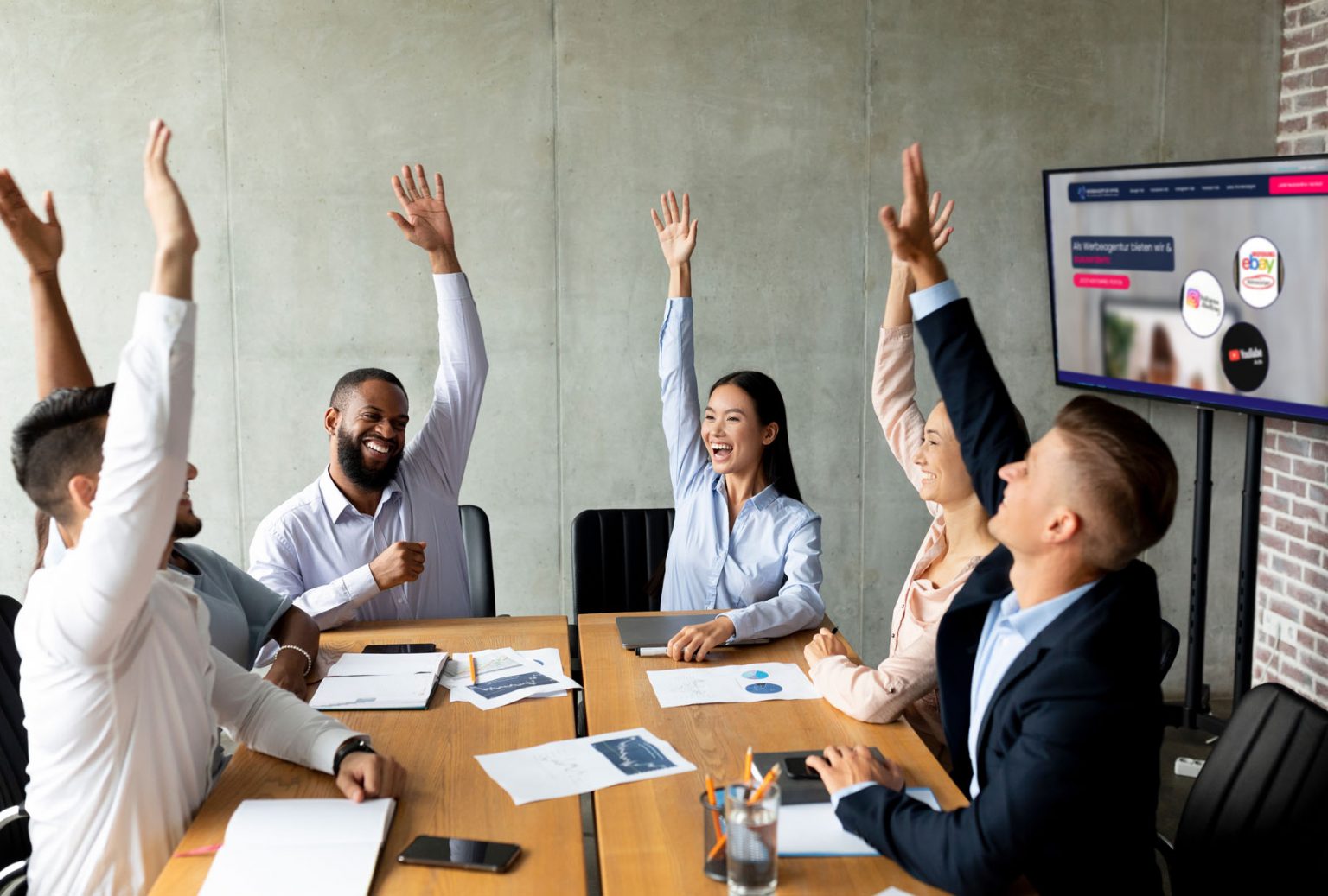 Symbolbild: jubelndes Team am Konferenztisch – SEO Agentur Blitz Berlin