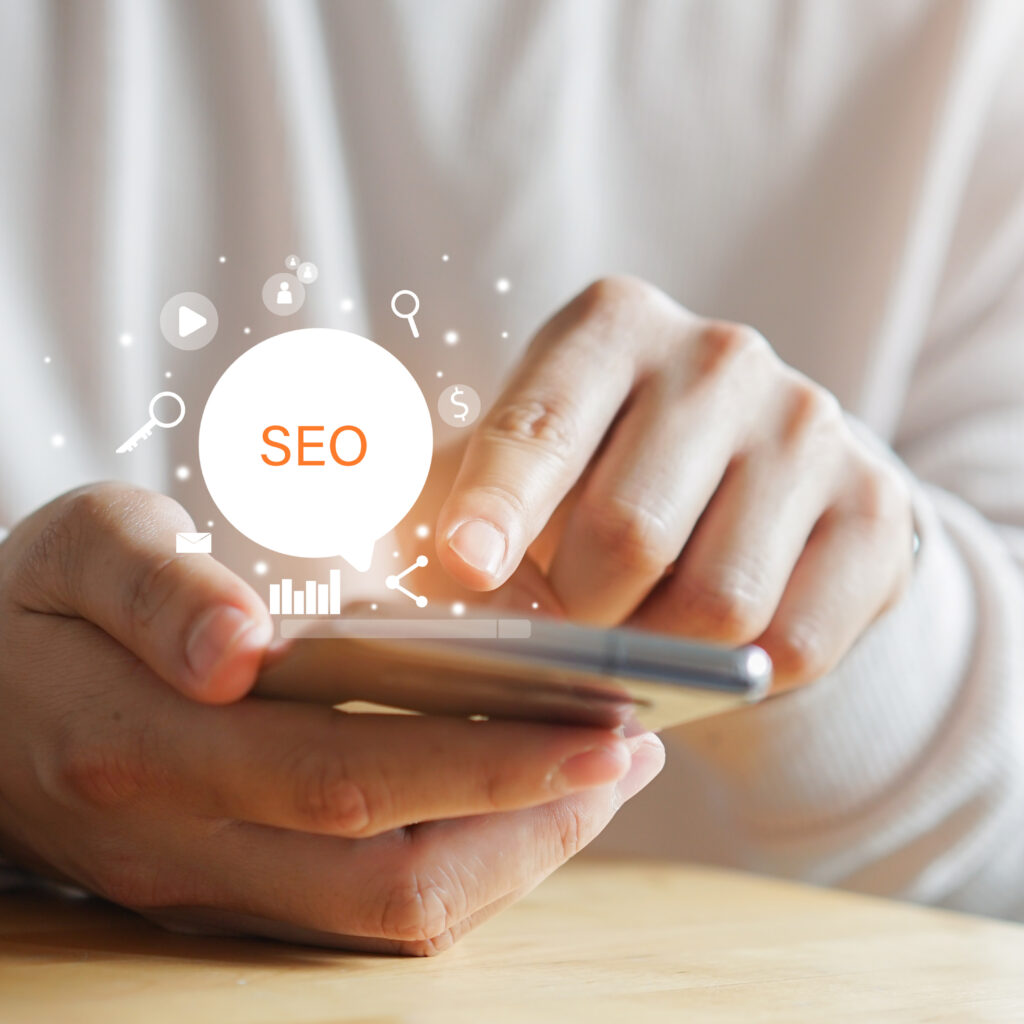SEO Optimierung Berlin – Hände halten Smartphone mit leuchtendem Symbol